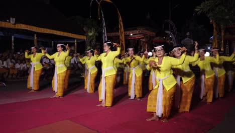 Los-Bailarines-Realizan-La-Danza-Tradicional-Balinesa-En-Bali,-Indonesia,-El-Espectáculo-Del-Templo-Hindú-Con-Ropa-Amarilla-Sagrada-Kebaya,-Coreografía-De-Rejang-Sari-Por-La-Noche