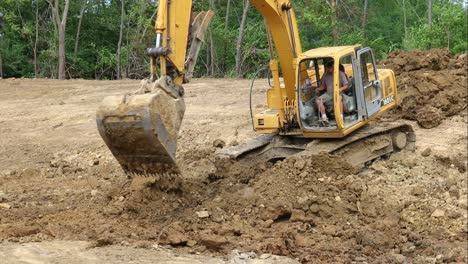 John-Deere-hydraulic-excavator-digging-dirt-from-bottom-of-pond-and-moving-it-to-top-of-side-wall-of-pond-then-repositioning-the-machine