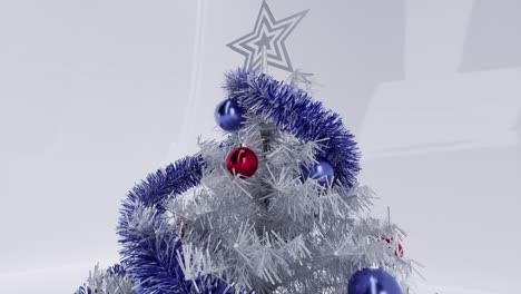 Weißer-Weihnachtsbaum-Mit-Blauen-Und-Roten-Kugeln,-Ornamenten-Und-Einem-Weißen-Stern-Auf-Weißem,-Glänzendem-Hintergrund