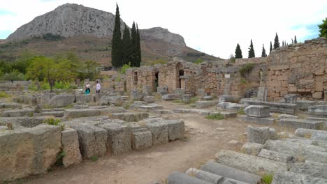 Ruinas-De-La-Tienda-Del-Oeste-En-La-Antigua-Corinto-Con-La-Montaña-Acrocorinto-En-Segundo-Plano