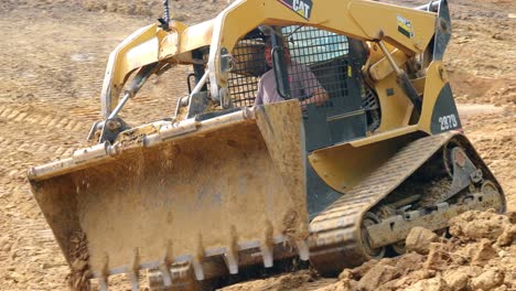 Caterpillar-287B-Skid-Steer-Loader-dumps-dirt-and-then-reverses-to-reposition-to-start-another-cycle-to-prepare-a-site-for-a-new-pond