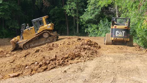 Caterpillar-287B-Skid-Steer-Loader-and-D6T-Bulldozer-work-together-to-move-dirt-complete-the-top-bank-for-a-new-pond:-concepts-of-cooperation-and-new-construction