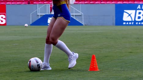 Brazilian-girl-dribbles-football-around-cones,-slow-motion