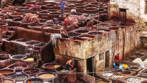 Filling-vats-with-water-and-mysterious-chemicals-and-dyes-and-treading-with-their-feet-in-an-ancient-traditional-tanning-process-for-animal-skins---time-lapse
