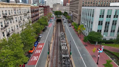 Subway-train-travels-through-neighborhood-street-in-historical-Boston,-MA