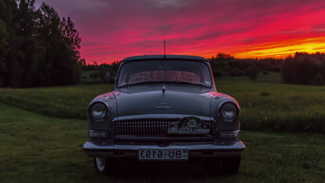 A-classic-Soviet-era-classic-car,-the-GAZ-21-in-the-countryside-during-a-vibrant-sunset---time-lapse