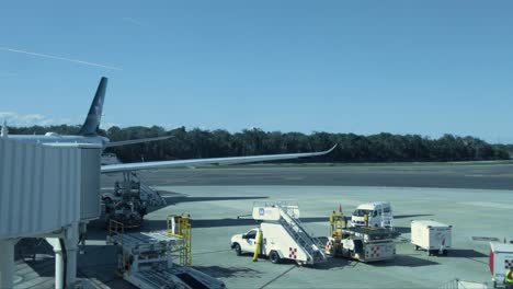 Schwenk-Eines-Flugzeugs,-Das-Auf-Dem-Flughafen-Von-Cancun-Landet,-Mit-Einem-Anderen-Flugzeug-Auf-Dem-Transit-Und-Zwei-Geparkten-Flugzeugen