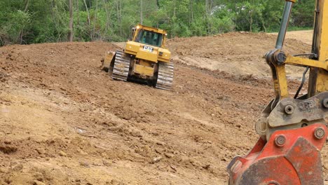 Large-and-powerful-Caterpillar-bulldozer-working-on-a-slope-to-form-the-side-of-a-pond-at-a-new-land-development-site