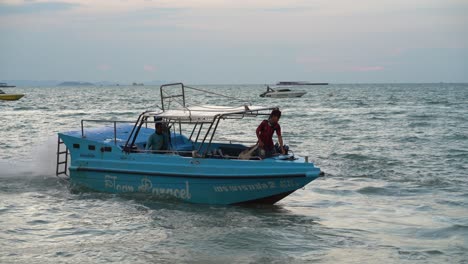 Tourist-boat-workers-are-trying-to-moor-the-boat-near-the-beach-in-Pattaya,-Thailand