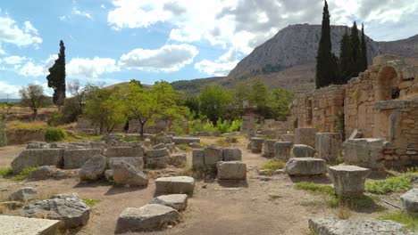 Panoramic-View-of-West-Shop-in-Ancient-Corinth-with-Acrocorinth-Mountain-in-Background
