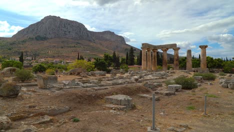 Tempel-Des-Apollo-Im-Alten-Korinth-Mit-Acrocorinth-berg-Im-Hintergrund-Mit-Blauem-Himmel