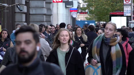 In-slow-motion-people-walk-along-a-busy-on-Oxford-Street-during-the-day