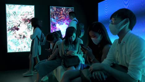 Chinesische-Besucher-Nutzen-Smartphones,-Um-Mit-Kunstinstallationen-Auf-Der-Digital-Art-Fair-Zu-Interagieren-Und-Zukunftstrends-Wie-Web-3-Zu-Präsentieren