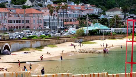 People-swimming-in-sunny-Kalk-Bay-ocean-Cape-Town-coastline-beach-South-Africa