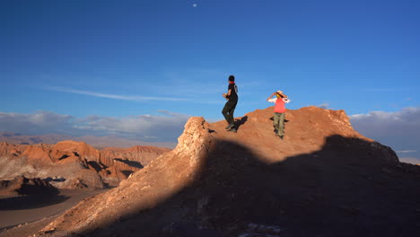Pareja-Disfrutando-De-Vistas-épicas-Desde-La-Cima-De-Una-Montaña-Ventosa-En-El-Desierto-De-Atacama