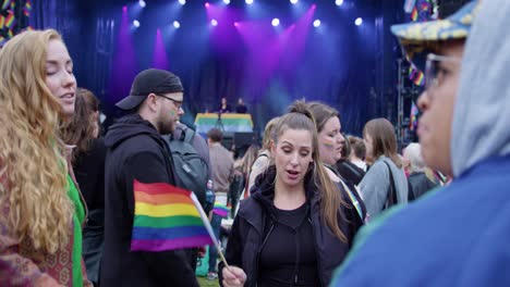 Women-dancing-and-singing-in-Oslo-Pride-2022,-glowing-stage-in-background