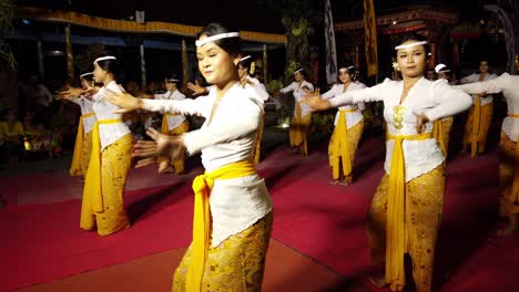 Artistic-females-performing-ancient-religious-dance,-Balinese-Temple-art-tradition-decorative-costumes-part-of-spiritual-mythology-Indonesia-travel-and-tourism