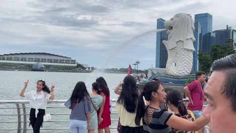 Tourists-pose-and-take-photos-of-Marina-Bay-Sands-and-the-iconic-landmark-of-Singapore-Merlion