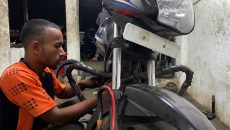 Motorradmechaniker-Aus-Bangladesch,-Der-Am-Motor-In-Der-Garage-In-Sylhet-Arbeitet