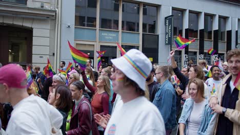 Endless-crowd-marching-and-waving-rainbow-flags-in-Oslo-downtown,-Oslo-Pride-2022