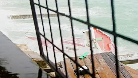 Local-wooden-fishing-boat-being-smashed-into-pieces-during-sudden-storm-with-rough-waves,-Caribbean