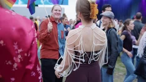 Woman-with-fancy-outfit-dancing-in-Oslo-Pride-2022-festival,-back-view
