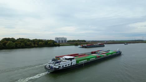 Aerial-View-Of-Virage-Cargo-Ship-Travelling-Along-Oude-Maas-With-Barge-Carrying-Cargo-Containers