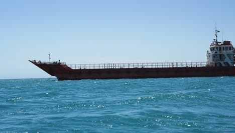 Barco-De-Transporte-Con-Dolor-Oxidado-Navegando-En-El-Océano-índico-Cerca-De-La-Costa-Este-De-África,-Vista-Desde-Un-Bote-Pequeño