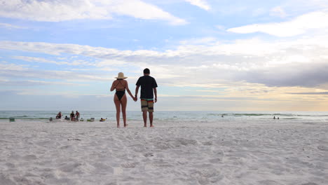 Couple-Walking-Towards-Sea-On-Florida-Sandy-Beach