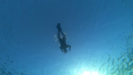 View-Below-Male-Free-Diver-Floating-On-Surface-In-Open-Sea