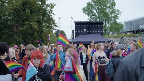 Crowd-celebrating-Oslo-Pride-2022-with-rainbow-flags-and-dancing,-front-view
