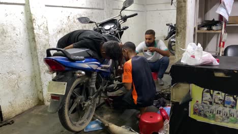 Grupo-De-Mecánicos-Que-Trabajan-En-El-Motor-De-La-Moto-Dentro-Del-Garaje-En-Sylhet