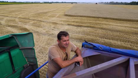 A-farmer-takes-a-break-from-harvesting-wheat-crop-fields-during-the-summer-in-Ukraine