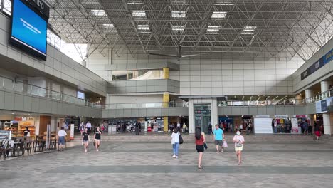 People-walk-around-Toa-Payoh-Square,-outside-bus-interchange-in-Singapore