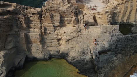 2-Jungs-Klettern-Eine-Gefährliche-Klippe-In-Sa-Pedrera-De-Cala-D&#39;Hort,-Spanien,-Hinunter