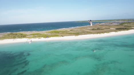 Puesta-De-Sol-Mágica-Mar-Caribe-Con-Hombre-Kitesurf-Frente-A-La-Playa-Isla-Crasqui,-Drone-Shot-Los-Roques