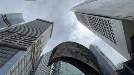 Tilt-up-view-of-the-Progress-and-Advancement-Sculpture-against-the-skyscrapers-,-Raffles-Place