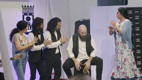 Flamenco-group,-with-man-playing-cajon,-at-tourism-trade-show,-Madrid,-Spain