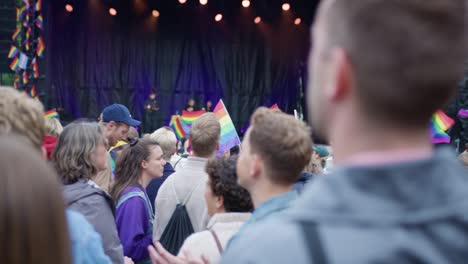 People-with-rainbow-flags-enjoy-Oslo-Pride-2022-performers-on-stage,-POV