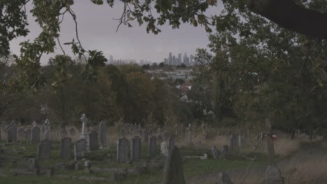 Cityscape-Canary-Wharf,-UK-Financial-District-from-Cemetery,-gravestones-in-foreground