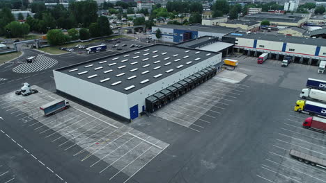 Vista-Aérea-De-Drones-Del-Centro-Logístico-Y-Camiones-Estacionados-En-La-Zona-Industrial-De-Riga-En-Letonia