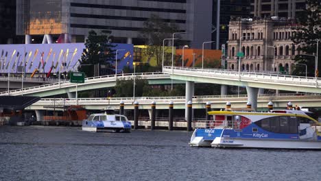 Establishing-static-shot-capturing-busy-traffic-on-riverside-expressway,-queens-wharf-road-and-pacific-motorway-and-Kittycat-and-citycat-ferries-sailing-on-Brisbane-river-at-central-business-district