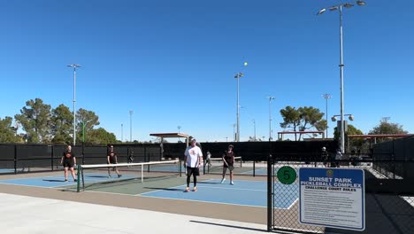 People-play-the-sport-pickleball-on-outdoor-courts-in-summer-sun