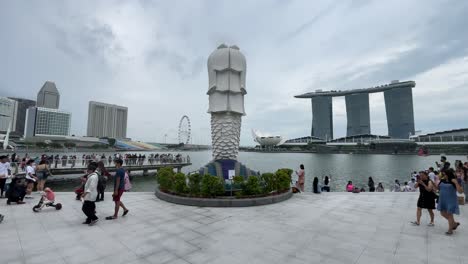 People-stroll-and-take-photos-at-Merlion-Park-overlooking-the-view-of-Marina-Bay-in-Singapore