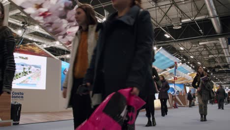 Wide-angle-shot-in-side-FITUR-exposition,-majority-women-professionals-walking-by