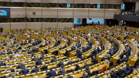 European-Parliament-congress-plenary-hall-with-politicians-applauding-after-speech-in-Brussels,-Belgium---panning-shot