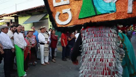 Gente-Mirando-A-Los-Dos-Hombres-Con-Trajes-Tradicionales-Y-Máscaras-Recreando-La-Pelea-De-Espadas-Durante-El-Evento-De-Danza-Ancestral-En-Tuxpan,-Jalisco,-México