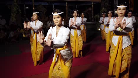 Niñas-Bailando-En-El-Templo-Balinés,-Danza-Bali-De-Indonesia,-Ceremonia-Religiosa-En-La-Tradición-Hindú,-Vistiendo-Trajes-Blancos-Y-Amarillos,-Oferta-Para-Dar-La-Bienvenida-A-Los-Dioses