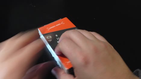 Unwrapping-hardware-crypto-wallet-from-plastic-wrap,-close-up