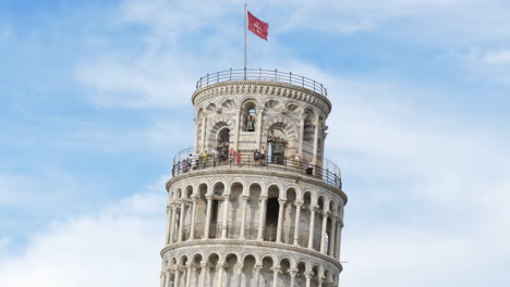 Cerrar-La-Parte-Superior-De-La-Torre-Inclinada-De-Pisa-Con-Bandera,-Fondo-De-Cielo-Estático